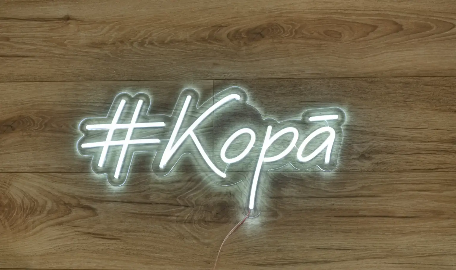 LED neona uzraksts #Kopā neitrāli baltā gaismā uz koka fona